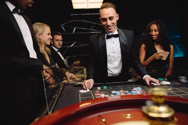 SUPERJILI — A high-class gaming experience without limits A woman in a luxurious green gown next to an ornate roulette wheel, capturing the upscale casino mood of SUPERJILI.